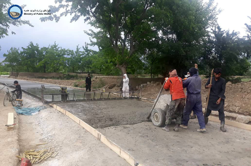 A rigid pavement road is under construction in the Bagram district
